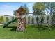 Backyard wooden playset with climbing wall, slide, swings and a lush green grass area at 5301 N 43Rd St, Phoenix, AZ 85018