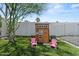 Charming backyard playhouse with pink chairs on a grassy lawn with white perimeter fencing at 5301 N 43Rd St, Phoenix, AZ 85018