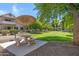 Picnic table with umbrella, barbeque and benches surrounded by green landscape at 616 S Hardy Dr # 203, Tempe, AZ 85281