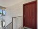 Apartment entrance with a red door, brown handrail, and textured stucco wall at 616 S Hardy Dr # 203, Tempe, AZ 85281