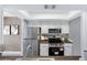 Updated kitchen with stainless steel appliances, white cabinets, and stylish backsplash at 616 S Hardy Dr # 203, Tempe, AZ 85281