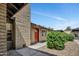 Front exterior of a brick home featuring a red door, well-kept landscaping, and covered parking at 6415 S Newberry Rd # A, Tempe, AZ 85283