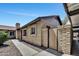 Side view of a single-story home with light brick and a private gated patio at 6415 S Newberry Rd # A, Tempe, AZ 85283