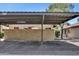 A covered parking area with marked spaces and a brick wall, providing shade and protection for vehicles at 6415 S Newberry Rd # A, Tempe, AZ 85283