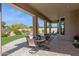 The back patio is covered with a table and chairs overlooking the well manicured yard and desert landscape at 6450 E Monterra Way, Scottsdale, AZ 85266