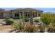 Charming backyard with desert landscaping, artificial turf, and covered patio with outdoor fireplace at 6450 E Monterra Way, Scottsdale, AZ 85266