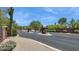 Gated community entrance with stone pillars, desert landscaping, and paved road at 6450 E Monterra Way, Scottsdale, AZ 85266