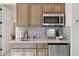 Kitchenette area features stainless steel appliances, mosaic backsplash and accent artwork at 6450 E Monterra Way, Scottsdale, AZ 85266