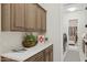 Laundry room area with ample storage space in the wooden cabinets and a neutral color scheme at 6450 E Monterra Way, Scottsdale, AZ 85266