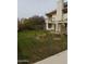 View of large, grassy backyard with balcony, storage shed, trees, and patio; perfect for entertaining at 7537 W Dreyfus Dr, Peoria, AZ 85381