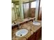 Bathroom featuring double sinks, granite countertops, and a shower at 7537 W Dreyfus Dr, Peoria, AZ 85381