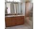 Bathroom featuring a double vanity with granite countertop and bathtub with glass doors at 7537 W Dreyfus Dr, Peoria, AZ 85381