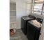 Functional laundry room with modern washer and dryer, storage shelves, and tile flooring at 8254 E Posada Ave, Mesa, AZ 85212