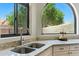 Stylish kitchen sink area with granite countertops, modern faucet, and a picturesque view of the lush backyard landscape at 8785 E Greenview Dr, Gold Canyon, AZ 85118
