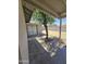 A covered back patio and spacious yard are shaded by a mature tree, perfect for outdoor living at 8936 W Mackenzie Dr, Phoenix, AZ 85037