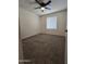 Cozy carpeted bedroom with a ceiling fan and bright window at 8936 W Mackenzie Dr, Phoenix, AZ 85037