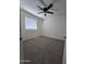 Carpeted bedroom featuring ceiling fan and light-filled window at 8936 W Mackenzie Dr, Phoenix, AZ 85037