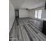 Bright living room boasts modern gray flooring and fan, with ample natural light at 8936 W Mackenzie Dr, Phoenix, AZ 85037