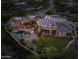 Aerial view of home with pool, solar panels, and a well manicured lawn at twilight at 9693 N 129Th Pl, Scottsdale, AZ 85259