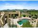 Inviting backyard with a sparkling pool, rock features, lush landscaping, and mountain views at 9693 N 129Th Pl, Scottsdale, AZ 85259