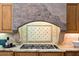 Close-up of a gas range, granite countertops, and a decorative backsplash in a stylish kitchen at 9693 N 129Th Pl, Scottsdale, AZ 85259