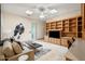 Spacious living area featuring custom shelving, a ceiling fan, and skylights for natural light at 9693 N 129Th Pl, Scottsdale, AZ 85259