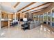 Open concept living area with a stone fireplace, beamed ceilings, custom built-ins, wet bar and large windows at 9693 N 129Th Pl, Scottsdale, AZ 85259