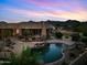 Backyard pool with waterfall feature and mountain views at twilight at 9693 N 129Th Pl, Scottsdale, AZ 85259