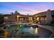 Backyard pool with waterfall feature and spa with desert landscaping at twilight at 9693 N 129Th Pl, Scottsdale, AZ 85259
