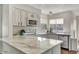 Modern kitchen with marble countertops, white cabinets, and stainless steel appliances at 101 N 7Th St # 225, Phoenix, AZ 85034