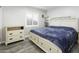 Serene bedroom with gray wood floors, dresser and a comfortable queen sized bed at 1015 E Paradise Ln, Phoenix, AZ 85022