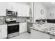 Updated kitchen featuring stainless steel appliances, including a microwave, stove, dishwasher, and sink with granite countertops at 1015 E Paradise Ln, Phoenix, AZ 85022