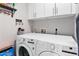 Functional laundry room with side-by-side white appliances, ample storage cabinets, and practical design elements at 1015 E Paradise Ln, Phoenix, AZ 85022