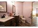 Bathroom with dual sinks, wood-look floors, wood cabinets and a toilet at 11596 W Sierra Dawn Blvd # 182, Surprise, AZ 85378