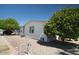 Well-maintained single-story home with desert landscaping, mature trees, and a convenient outdoor area at 11596 W Sierra Dawn Blvd # 182, Surprise, AZ 85378