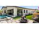 Relaxing backyard featuring a pool, artificial grass, covered patio, and a fire pit at 1217 E Monte Way, Phoenix, AZ 85042