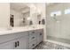 Bathroom features a double sink vanity and a tiled walk-in shower with a window at 1217 E Monte Way, Phoenix, AZ 85042