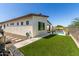 Side and backyard of a modern house featuring artificial grass, decorative rocks, and a desert landscape at 1217 E Monte Way, Phoenix, AZ 85042
