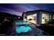 Backyard with pool, spa, outdoor seating and lush desert landscaping lit under an evening sky at 1217 E Monte Way, Phoenix, AZ 85042