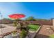 Landscaped backyard with a covered patio, artificial turf, and decorative rock at 1284 W Sussex St, San Tan Valley, AZ 85143