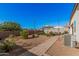 Gravel backyard features a patio, gravel, shrubs, privacy wall, and string lights at 1284 W Sussex St, San Tan Valley, AZ 85143