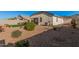 Fully landscaped backyard with gravel, mature shrubs, patio, and privacy wall at 1284 W Sussex St, San Tan Valley, AZ 85143