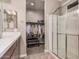 Bathroom featuring double sinks, white counters and cabinets, a glass shower and a walk-in closet at 1284 W Sussex St, San Tan Valley, AZ 85143