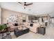 Cozy living room showcasing an oversized sectional sofa, ceiling fan, and seamlessly connects to the kitchen at 1284 W Sussex St, San Tan Valley, AZ 85143