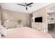 Bright bedroom featuring a ceiling fan, white dressers, and access to the ensuite bathroom at 1284 W Sussex St, San Tan Valley, AZ 85143
