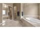 Bright bathroom features a soaking tub, walk-in shower with glass doors and tile flooring at 15600 E Robin Dr, Fountain Hills, AZ 85268