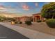 Charming single-story home featuring a three-car garage and desert landscaping at sunset at 15600 E Robin Dr, Fountain Hills, AZ 85268