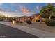 Inviting single-story home with a three-car garage and desert landscaping, illuminated beautifully against the sunset at 15600 E Robin Dr, Fountain Hills, AZ 85268