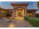 Inviting front entrance with a covered porch, desert landscaping, and pathway lighting for evening ambiance at 15600 E Robin Dr, Fountain Hills, AZ 85268