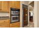 Modern kitchen with a stainless steel double oven, wine cooler, and granite countertops at 15600 E Robin Dr, Fountain Hills, AZ 85268